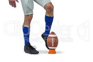 American football player kicking ball
