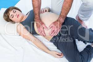 Physiotherapist giving massage to pregnant woman