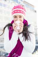 Smiling woman drinking from white cup