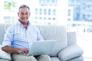 Happy man working on laptop at home