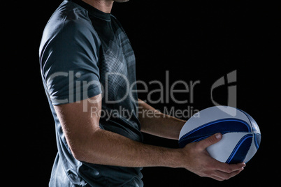 Midsection of rugby player holding ball