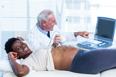 Smiling doctor showing movements of baby on screen