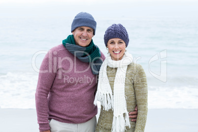 Smiling happy couple both wearing scarfs and hats