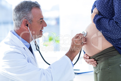 Male doctor examining pregnant woman in clinic