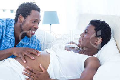 Man touching pregnant woman tummy
