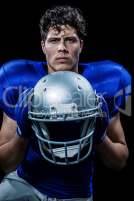 Portrait of determined sportsman holding helmet