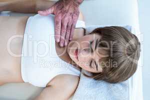High angle view of therapist performing reiki over woman