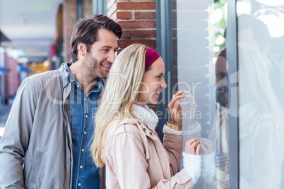 Smiling couple going window shopping