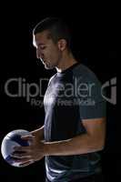 Rugby player thinking while holding ball