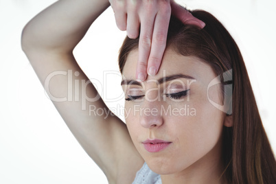 Woman meditating with hand on forehead