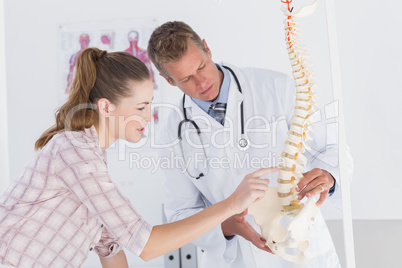 Doctor explaining anatomical spine to his patient Doctor explaining anatomical spine to his patient