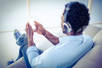 Man using smartphone while listening to music