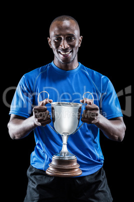 Portrait of happy athlete holding trophy