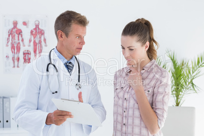 Doctor showing clipboard to his patient