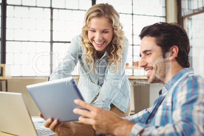 Colleagues using digital tablet in office