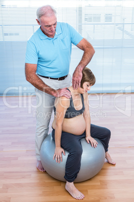 Male therapist massaging pregnant woman