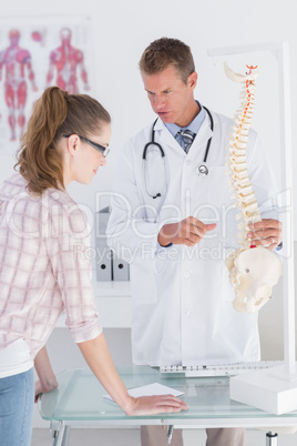 Doctor explaining a spine model to patient