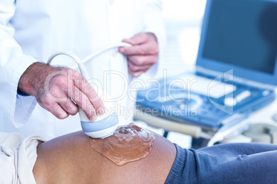 Doctor applying gel on belly of pregnant woman