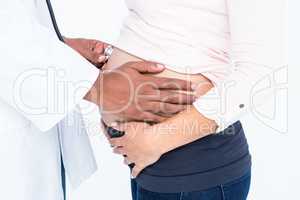 Midsection of doctor examining pregnant woman
