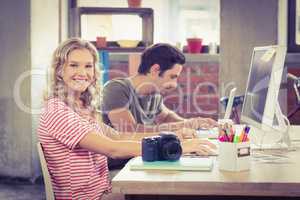 Portrait of smiling businesswoman working with colleague in offi