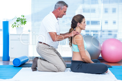 Gym trainer massaging pregnant woman