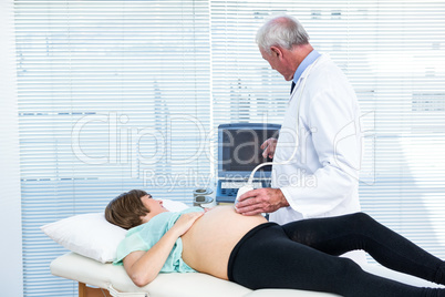Doctor showing ultrasound results to pregnant woman