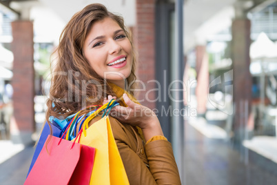 Portrait of smiling woman with shopping bags looking at camera