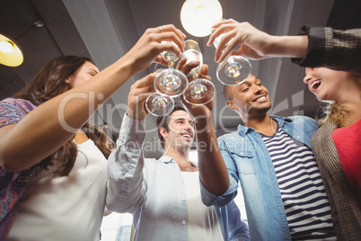 Low angle view of happy colleagues toasting with champagne