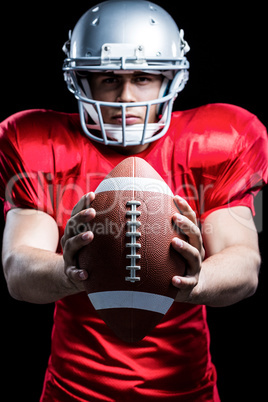 Portrait of American football player holding ball