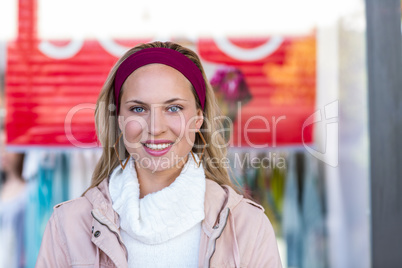 Smiling woman in front of sale sign