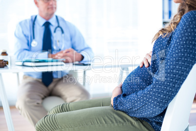 Pregnant woman with male doctor in clinic