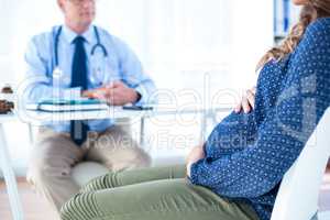 Pregnant woman with male doctor in clinic