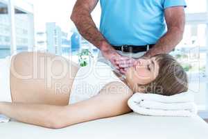 Pregnant woman relaxing while male therapist performing reiki