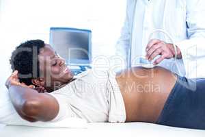 Pregnant woman smiling while doctor performing ultrasound