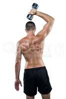 Rear view of shirtless athlete working out with dumbbell