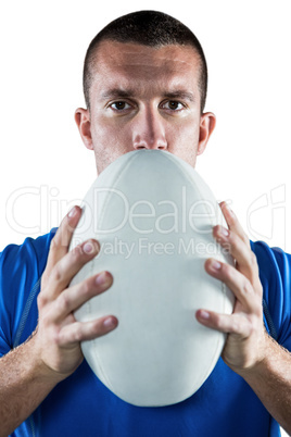 Portrait of confident rugby player in blue jersey holding ball
