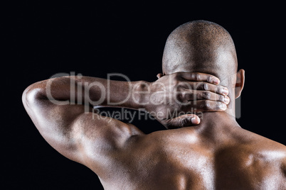 Rear view of athlete massaging neck