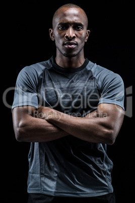 Portrait of athlete standing with arms crossed