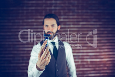 A bearded man holding a razor