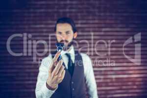 A bearded man holding a razor