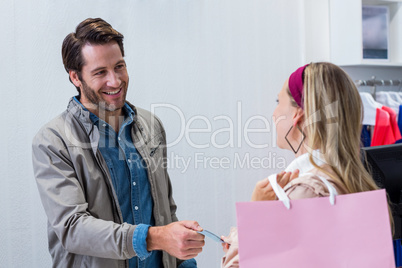 Smiling cashier handing back credit card