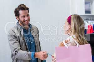 Smiling cashier handing back credit card