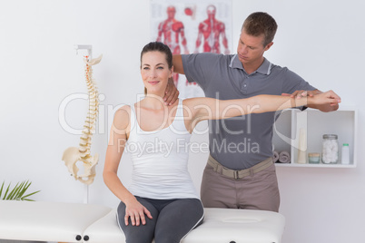 Doctor stretching a young woman arm