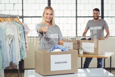 Portrait of smiling volunteer gesturing thumbs in office