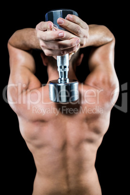 Shirtless crossfiter working out with dumbbell