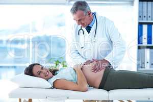 Portrait of pregnant woman examined by doctor in clinic