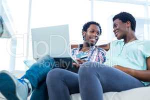 Couple smiling and sitting on sofa