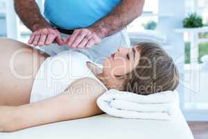 Therapist performing reiki over pregnant woman