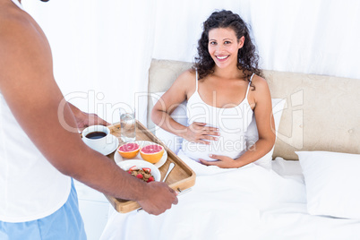 Husband with breakfast tray for pregnant wife