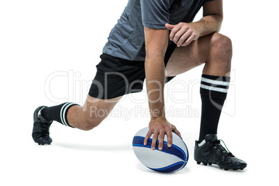 Rugby player in black jersey stretching with ball